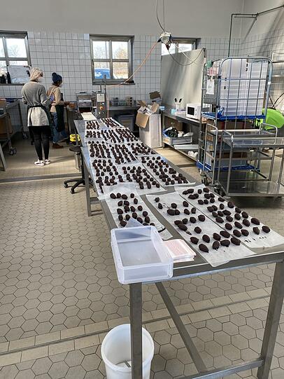 An langen Tischen werden die Pralinen vorbereitet. An langen Tischen werden die Pralinen vorbereitet.