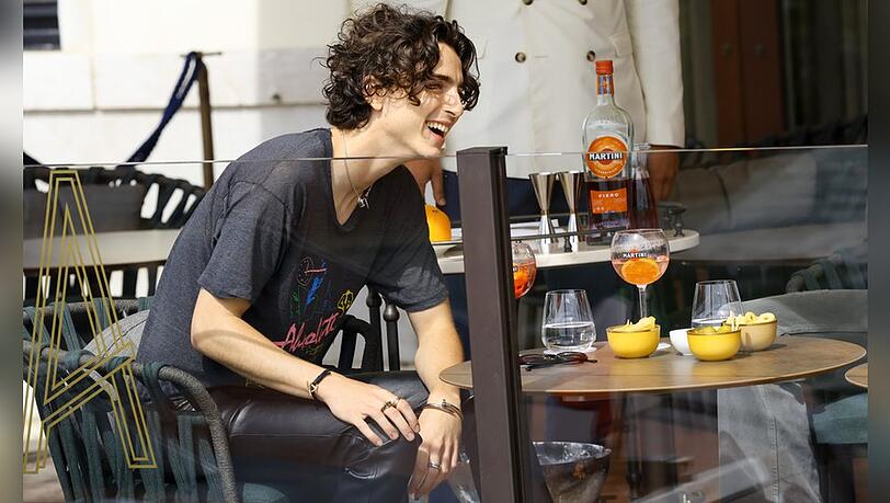 Timothée Chalamet im Vorfeld der Filmfestspiele auf der Terrasse des St. Regis Venice Hotels - betont leger in schwarzer Lederhose und T-Shirt, mit Snacks und einem Martini Fiero & Tonic.