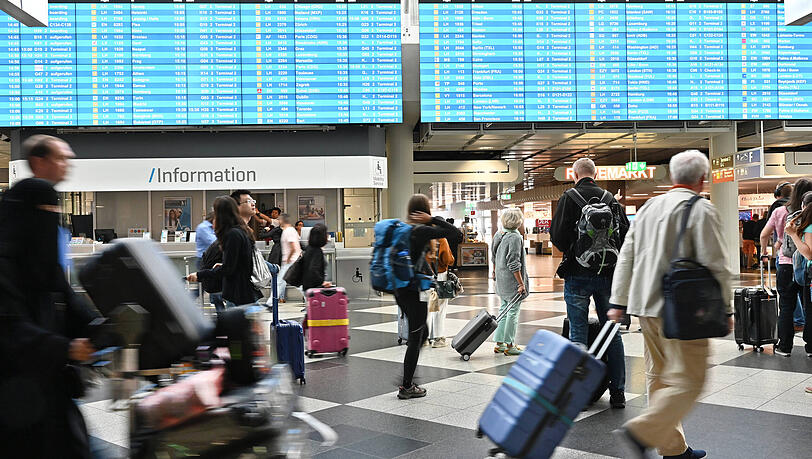 Passagiere am Flughafen M&uuml;nchen mit ihren Gep&auml;ckst&uuml;cken.