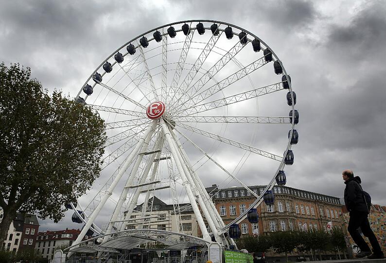 Dunkle Wolken ziehen in Düsseldorf über das Riesenrad in der Altstadt.