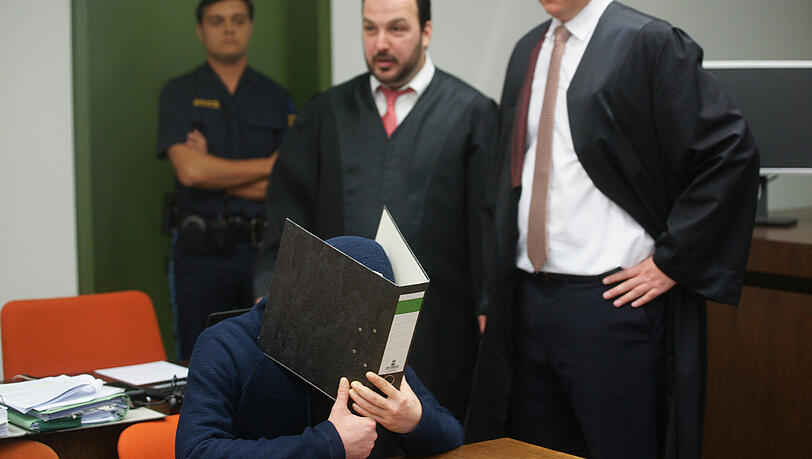 Angeklagter Daniel K. verbirgt sich hinter einem Aktenordner. Angeklagter Daniel K. verbirgt sich hinter einem Aktenordner.