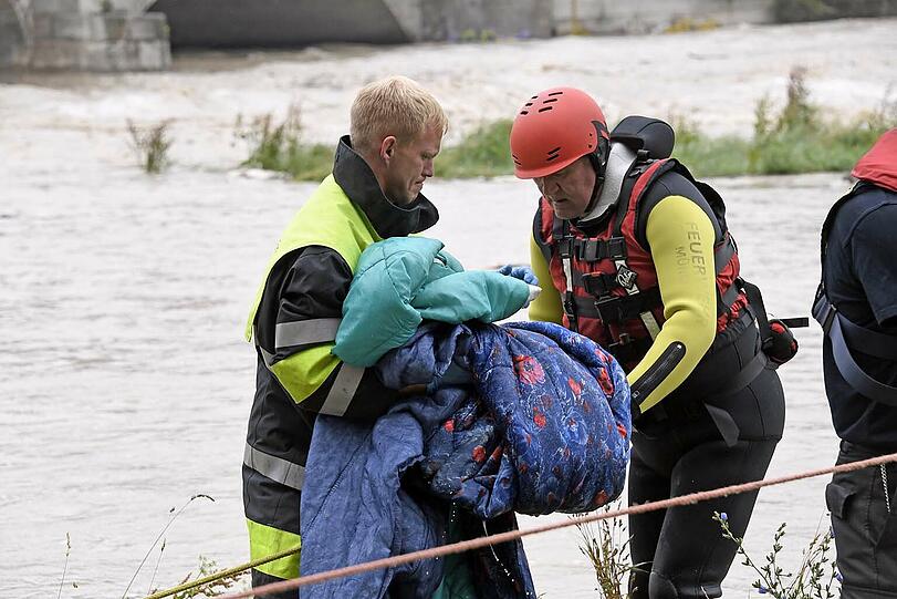 Einsatzkräfte der Wasserrettung bergen Habseligkeiten aus dem Obdachlosenlager unter der Reichenbachbrücke.