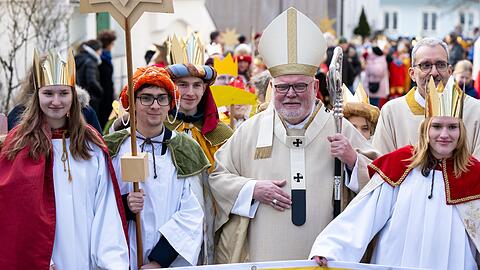 Goldene Krone, der Stern von Bethlehem und eine Sammelbüchse: Ab Montag sind wieder Sternsinger in der Stadt für den guten Zweck unterwegs. Hier sind sie 2023 mit Kardinal Reinhard Marx zu sehen.  dpa