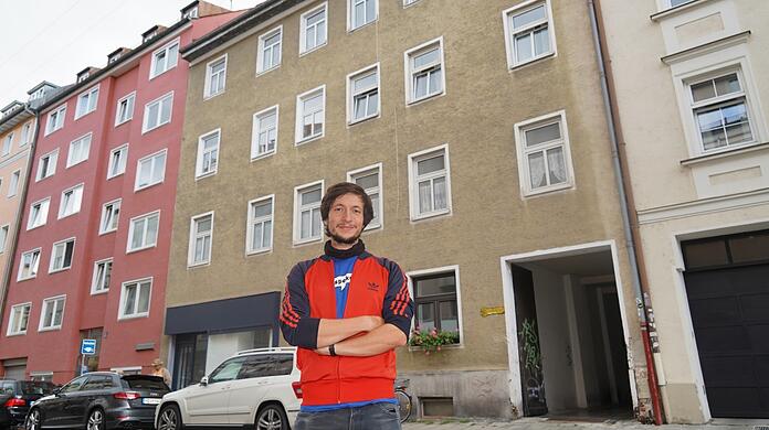 Mieteraktivist Christian Schwarzenberger vor einem vierstöckigen Wohnhaus in der Zieblandstraße, in dem mehrere Wohnungen unbewohnt sind.