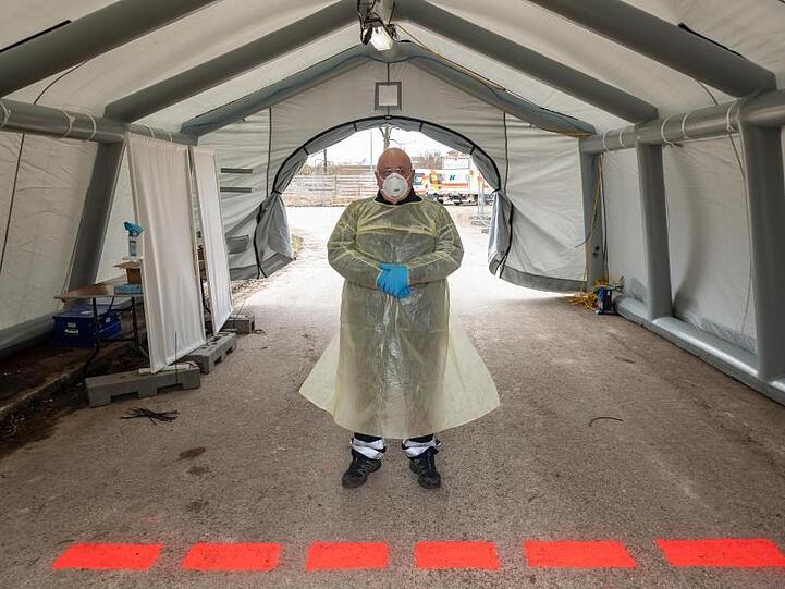 Medizinisches Personal wartet an einer neuen Drive-in-Teststation in der ehemaligen Bayern-Kaserne. Foto: Peter Kneffel/dpa