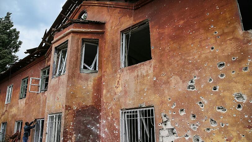 Ein Haus in Khartsyzk, etwa 24 Kilometer von Donetzk entfernt, ist mit Einschusslöchern übersät. Ein Haus in Khartsyzk, etwa 24 Kilometer von Donetzk entfernt, ist mit Einschusslöchern übersät.