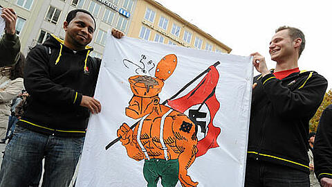 Zwei junge Männer tragen eine Karikatur gegen Nazis bei der Protestdemo gegen den &bdquo;Heldengedenkmarsch&ldquo; im vorigen Jahr.