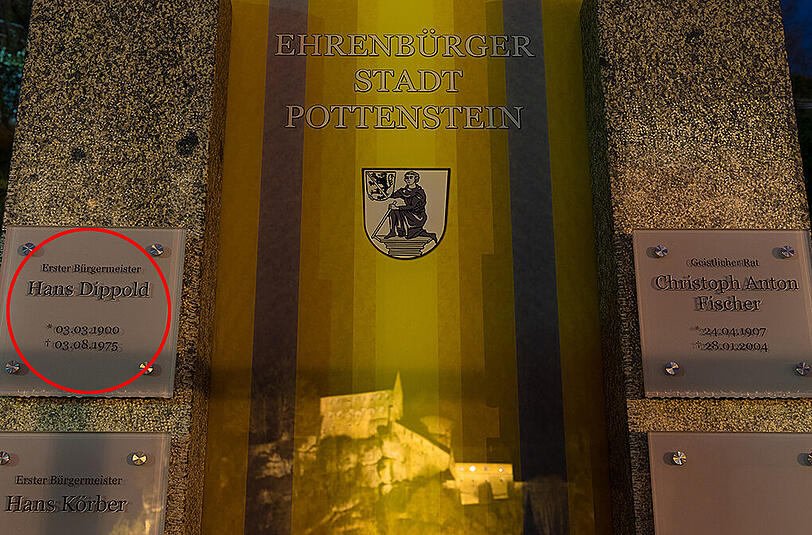 Links das Schild des Anstoßes mit der Ehrung für Hans Dippold auf dem Friedhof in Pottenstein.