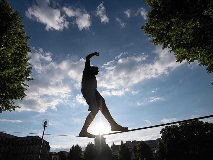 Person balanciert auf einer Slackline. Foto: Sebastian Gollnow/Archivbild