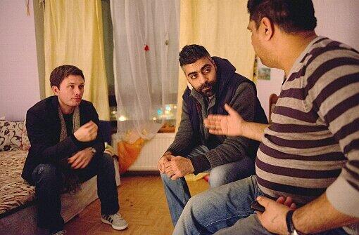 Der ZOF Mitarbeiter Jan Hündorf (l), Sozialarbeiter Murat Yasar (M) und Roma-Vater Stefan (r) sprechen am 06.01.2014 in Duisburg (Nordrhein-Westfalen) im "Problemhaus" miteinander. Seit Jahren klagen Städte über einen verstärkten Zuzug armer Zuwanderer. Die Familien kommen in verzweifelter Hoffnung auf ein besseres Leben
