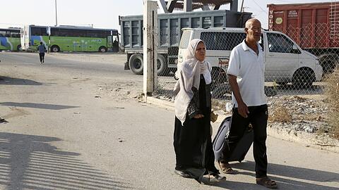 Ein reisendes Paar geht in Rafah (Palästinensische Autonomiegebiete) zum Bus, der sie über die Grenze nach Ägypten bringt.