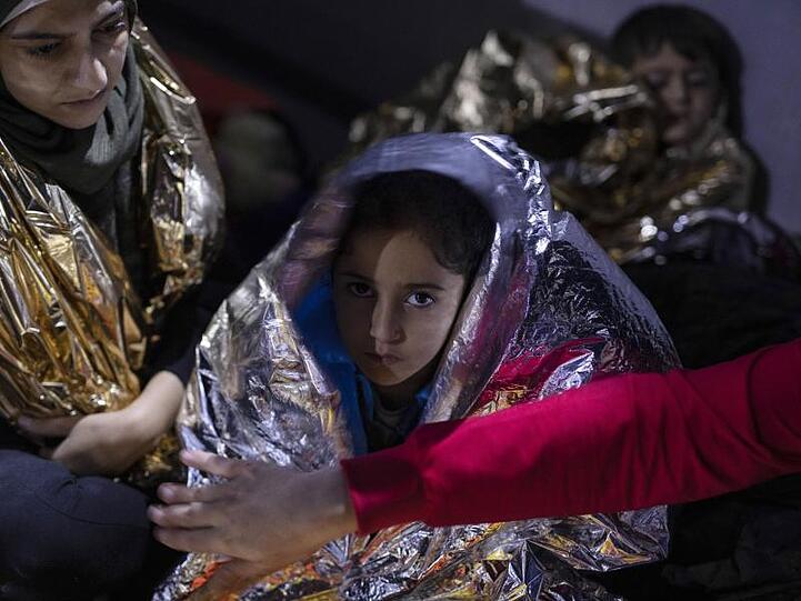 Ein irakisches Mädchen und anderen Flüchtlinge sind in Thermodecken gehüllt. 23 Migranten und Flüchtlinge aus Syrien, Irak, Palästina und dem Iran, die versuchten, mit einem Boot die Ägäis von der Türkei zur griechischen Insel Samos zu überqueren, wurden von der griechischen Küstenwache gerettet.
