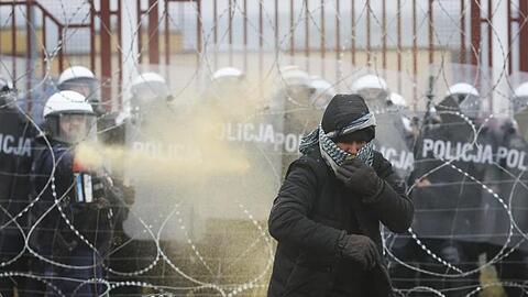 Ein Flüchtling wird von einem polnischen Soldaten mit Tränengas auf Distanz gehlten.