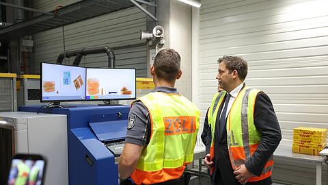 Finanzminister Klingbeil beim Rundgang mit den Zollbeamten zur &Uuml;berpr&uuml;fung von Paketen am DHL-Hub am Flughafen Leipzig/Halle.