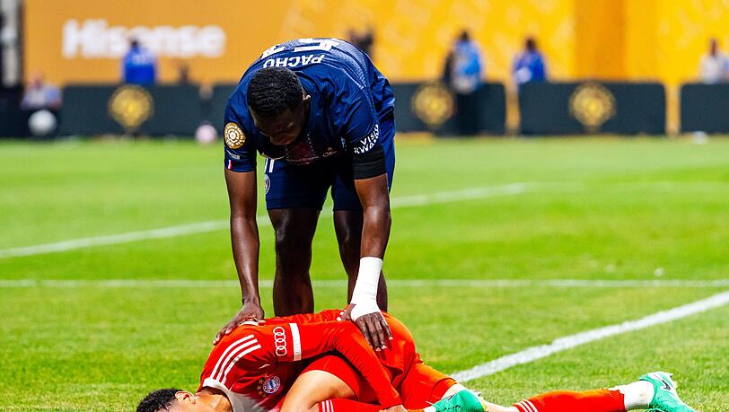 Jamal Musiala liegt mit starken Schmerzen verletzt am Boden. PSG-Profi William Pacho kümmert sich um ihn. Jamal Musiala liegt mit starken Schmerzen verletzt am Boden. PSG-Profi William Pacho kümmert sich um ihn.