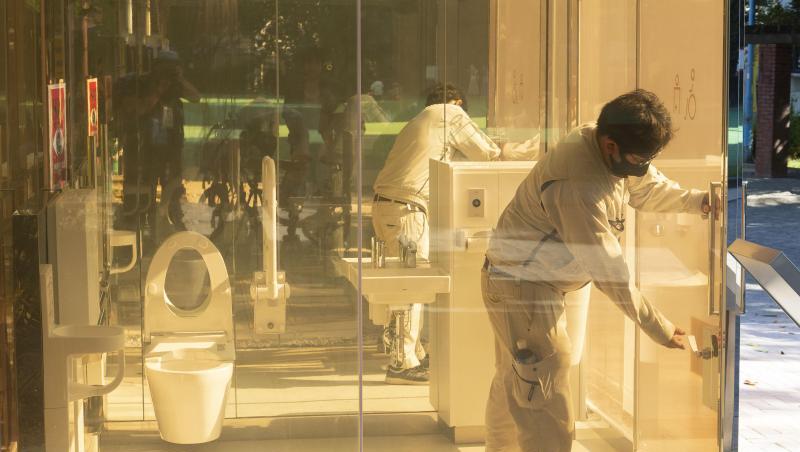 Ein Mann schließt die Tür einer neu installierten öffentlichen Toilette mit transparenten Wänden, die im Yoyogi Fukamachi Mini Park im Bezirk Shibuya steht. Die drei Toiletten aus transparentem Glas werden undurchsichtig, sobald jemand eintritt und die Tür verschließt. Ein Mann schließt die Tür einer neu installierten öffentlichen Toilette mit transparenten Wänden, die im Yoyogi Fukamachi Mini Park im Bezirk Shibuya steht. Die drei Toiletten aus transparentem Glas werden undurchsichtig, sobald jemand eintritt und die Tür verschließt.