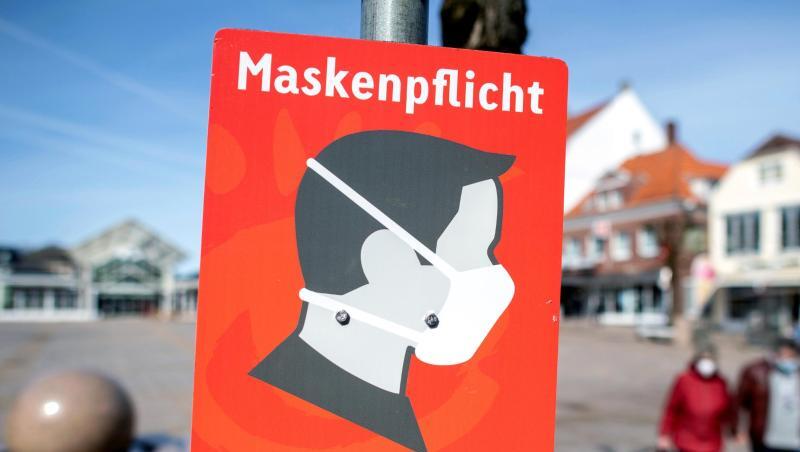 Ein Schild mit der Aufschrift "Maskenpflicht" hängt auf dem Marktplatz in der Innenstadt von Aurich.