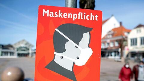Ein Schild mit der Aufschrift "Maskenpflicht" hängt auf dem Marktplatz in der Innenstadt von Aurich.