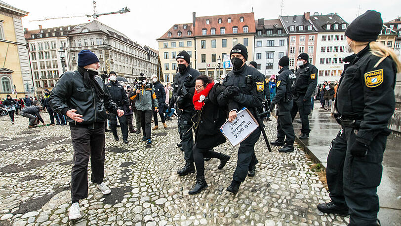 Polizisten führen eine Demo-Teilnehmerin ab.
