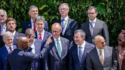 Merz stellt sich zum Familienfoto auf der COP30 auf.