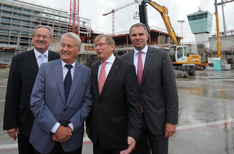 Münchens Oberbürgermeister Christian Ude (SPD), Architekt Norbert Koch, Flughafen-Chef Michael Kerkloh und Carsten Spohr, CEO Lufthansa German Airlines, stehen vor der Baustelle des Terminal-2-Satelliten.