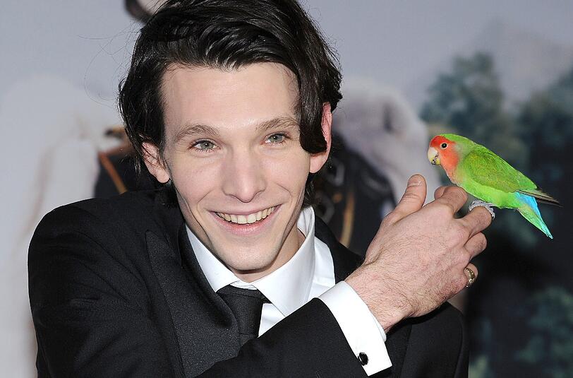 Der deutsch-rumänische Hauptdarsteller Sabin Tambrea posiert mit seinem Film-Vogel, dem Zwergpapagei "Edith".
