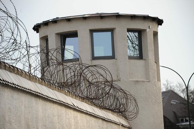 Ein Wachturm. Links im Bild die Stacheldraht-Windungen auf den Mauern.