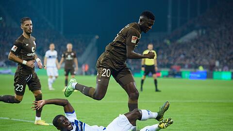 Darmstadts Braydon Manu (l) versucht St. Paulis Afeez Aremu vom Ball zu trennen.