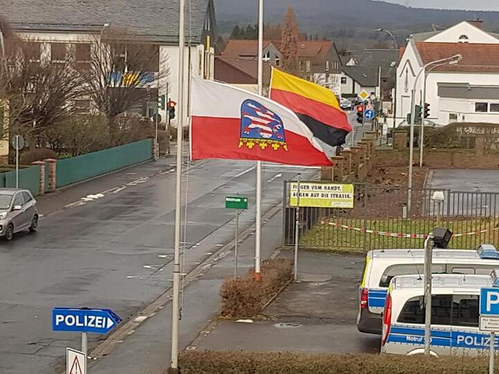 Die Deutschland- und die Hessenfahne sind am 27.01.2019, dem Tag des Gedenkens an die Opfer des Nationalsozialismus, vor einer Polizeiwache im osthessischen Schlüchtern kopfüber gehisst.