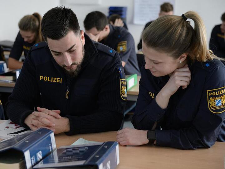 Salina Thom und Harun Aslantas (r-l) bearbeiten eine Aufgabe im Ethikunterricht der Bayerischen Polizei. Foto: Timm Schamberger/Archiv