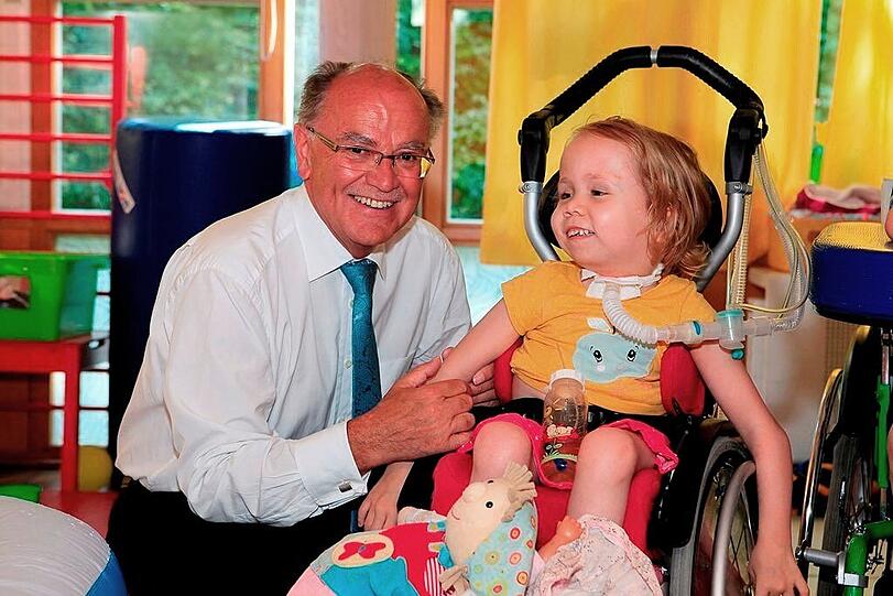 Die kleine Eila (6 Jahre) mit Stiftungsratsvorsitzendem Josef Mederer. Eila und alle Kinder im Kinderhaus AtemReich freuen sich über den großzügigen Scheck über 20.000 Euro.