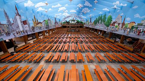 Bierbänke und Biertische stehen in einem Bierzelt.