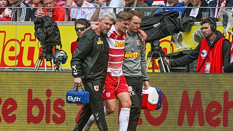 Elias Huth (M) von Regensburg wird verletzt vom Platz geführt.