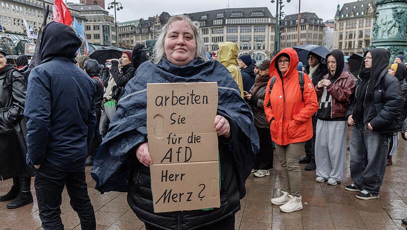 Eine Demonstrantin in Hamburg stellt auf einem Pappschild eine Frage an Bundeskanzler Friedrich Merz (CDU). Eine Demonstrantin in Hamburg stellt auf einem Pappschild eine Frage an Bundeskanzler Friedrich Merz (CDU).