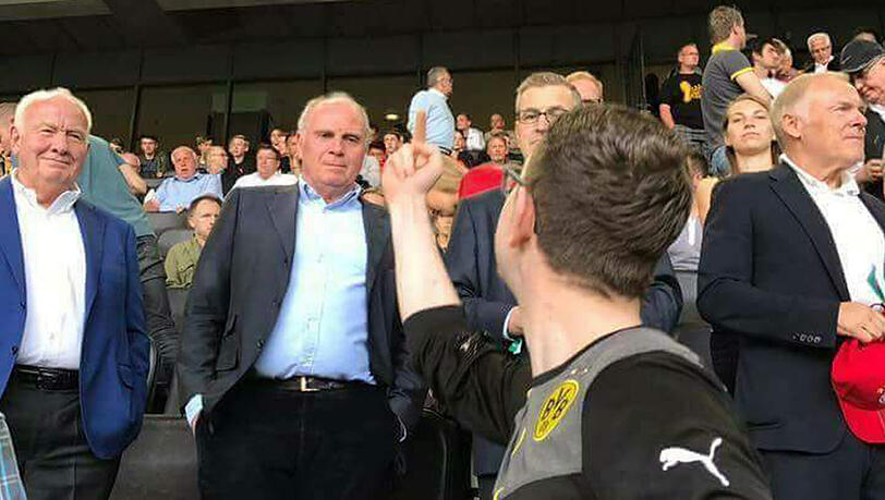Regungslos, aber vermutlich fassungslos registriert Bayern-Präsident Uli Hoeneß die eindeutige Geste des jungen BVB-Fans vor ihm auf der Tribüne des Signal Iduna Parks in Dortmund.