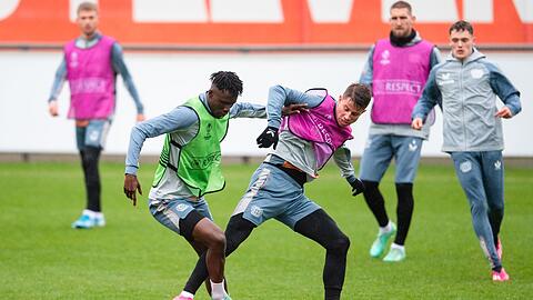 Leverkusens Odilon Kossounou (l) und Adam Hlozek kämpfen beim Training um den Ball.
