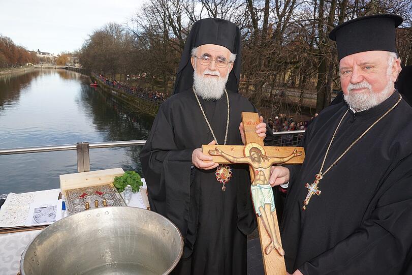 Bei der traditionellen Isarsegnung werfen die Gesitlichen das Holzkreuz drei Mal ins Wasser. Schwimmer holen es wieder herauf.