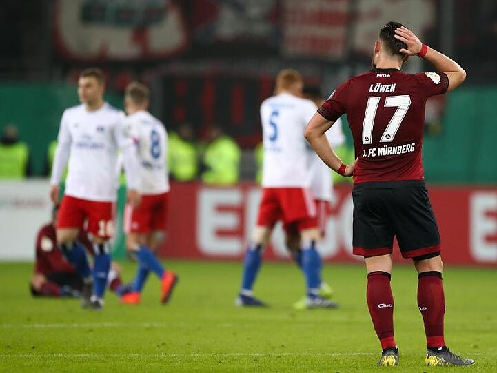 Eduard Löwen (r) vom FC Nürnberg steht nach dem 0:1 gegen den HSV verlorenen Spiel vor den Hamburger Spielern auf dem Platz.