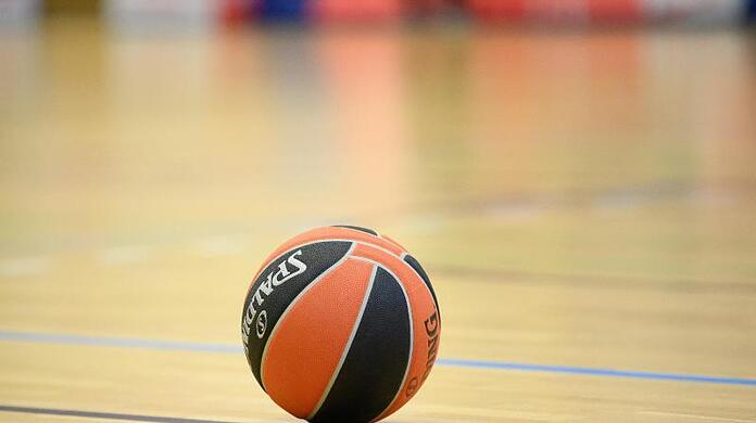 Ein Ball liegt auf einem Basketball-Spielfeld.