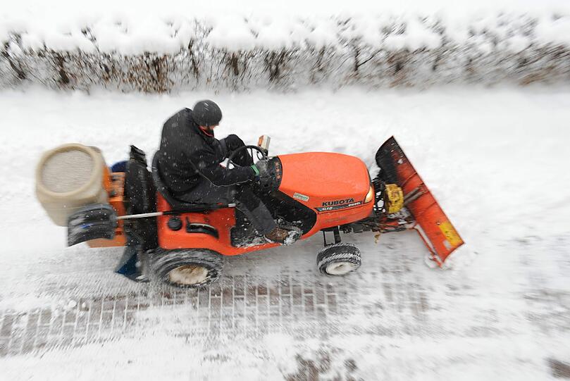 Ein Münchner befreit den Gehweg von den Schneemassen.
