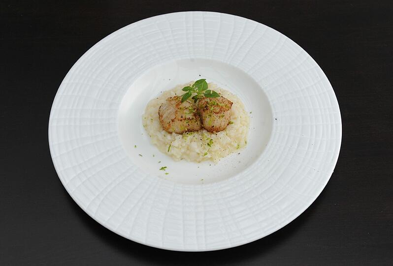 3. Gang: Jakobsmuschel &ndash; Limettenrisotto &ndash; Parmesan: Dieses Gericht in dem sonst herbstlichen Menü wird Sie noch einmal zurück in den Sommer versetzen. Ein Risotto, das nach Meer schmeckt, mit pikanten Limetten und einem Hauch Chili. Darauf gebettet zwei zarte Jakobsmuscheln. Die Weinbegleitung sorgt für eine eigene, fruchtige Note: Der Gewürztraminer &bdquo;Cuveé Valée Noble&ldquo; aus dem Elsass vom Weingut José Ebelmann und die Jakobsmuscheln bringen sich gegenseitig groß raus.