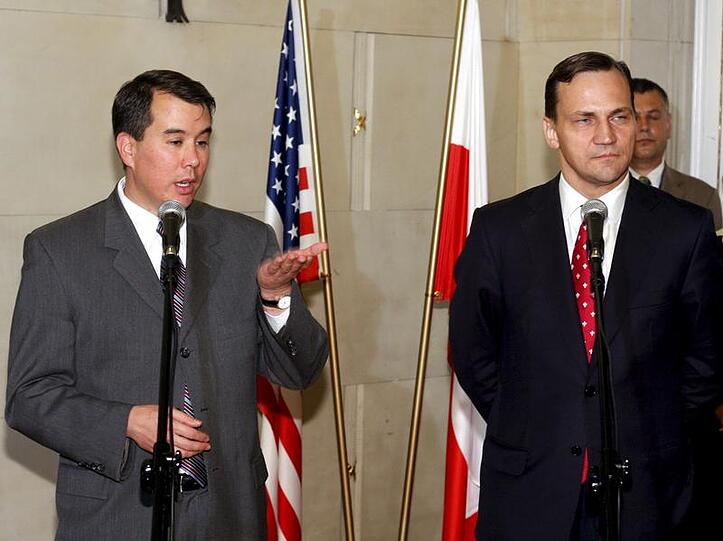 Der polnische Außenminister Radoslaw Sikorski (r) and US-Verhandlungsführer John Rood sprechen nach der Unterzeichnung der Vereinbarung in Warschau zur Presse.
