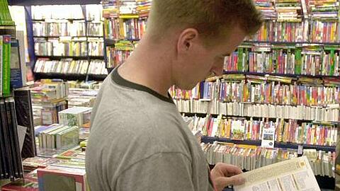 Ein Mann stöbert in einer Buchhandlung