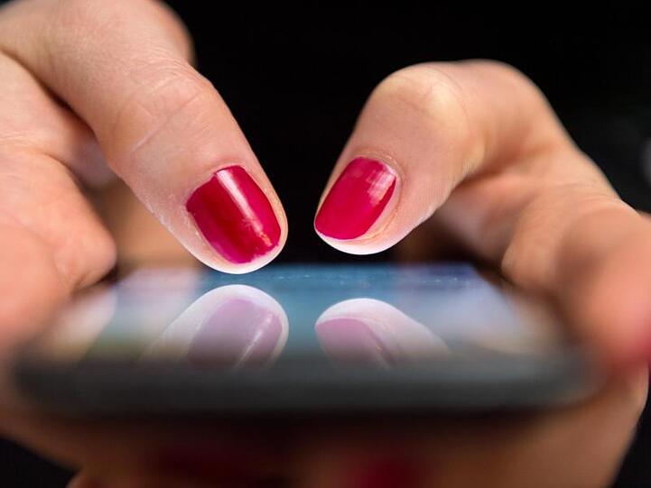 Eine Frau tippt auf einem Smartphone. Foto: Sebastian Gollnow/dpa/Archiv