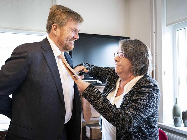 Joze Moonen schneidet Willem-Alexander die Krawatte ab. Der König nimmt es mit Humor.