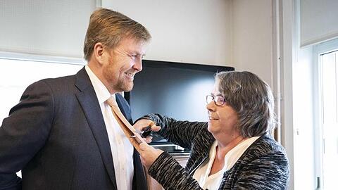 Joze Moonen schneidet Willem-Alexander die Krawatte ab. Der König nimmt es mit Humor.