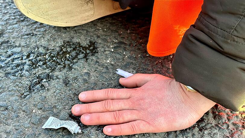 Eine Klimaaktivistin hat sich mit der Hand auf einer Hauptverkehrsstraße festgeklebt.
