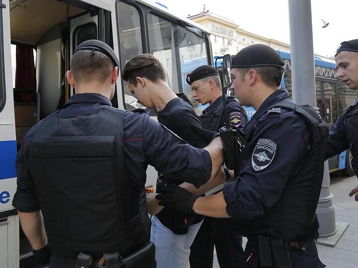 Polizeibeamte verhaften einen Mann vor der nicht genehmigten Kundgebung in Moskau.