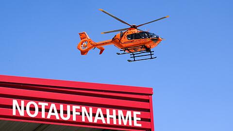 Ein Rettungshubschrauber der Luftrettung fliegt über einer Notaufnahme.