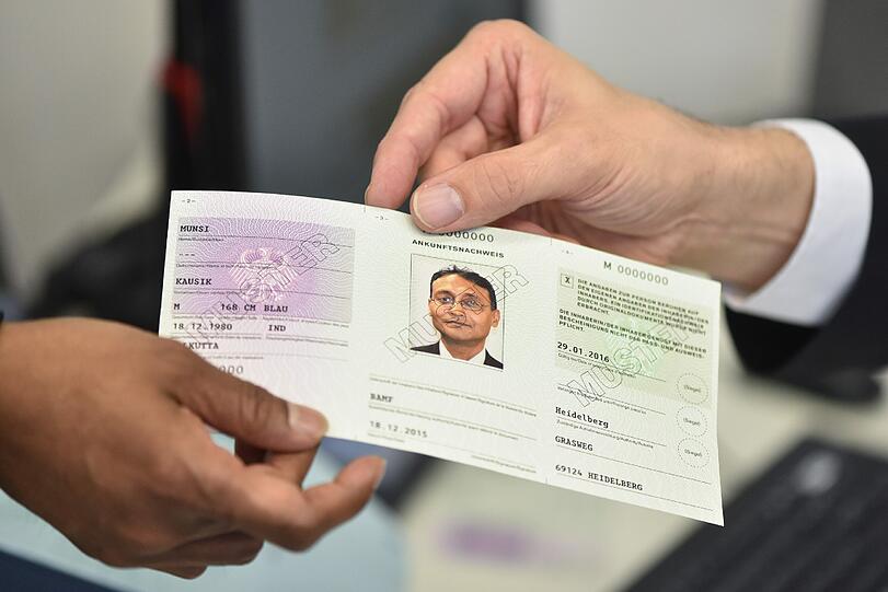 Ein Mitarbeiter des Bundesamtes für Migration und Flüchtlinge (Bamf) in Heidelberg in der Bamf-Außenstelle im Patrick-Henry-Village das Muster eines sogenannten Ankunftsnachweises für Flüchtlinge.